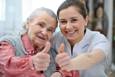 senior woman and female nurse showing thumbs up