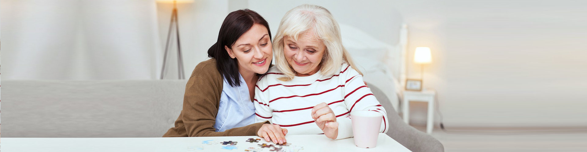 caregiver and senior woman playing with puzzles